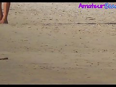 Attractive naked couple is walking down the beach, while a horny voyeur is taking hot photos